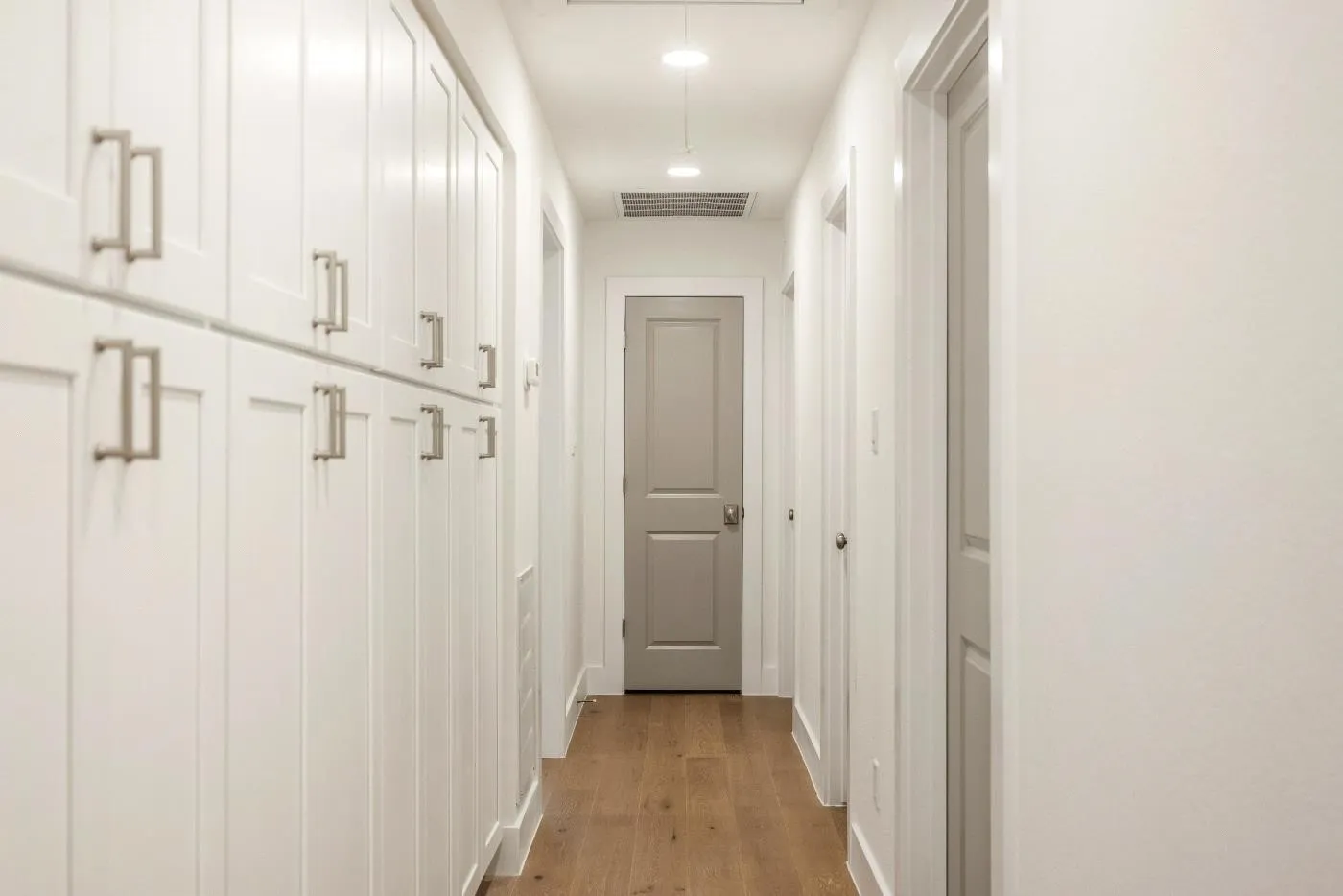 Hallway with built-in cabinets providing amble storage.