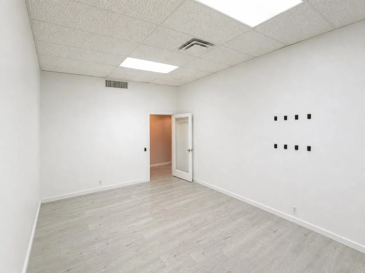 Recessed lighting, drop ceiling, and wood-finish flooring