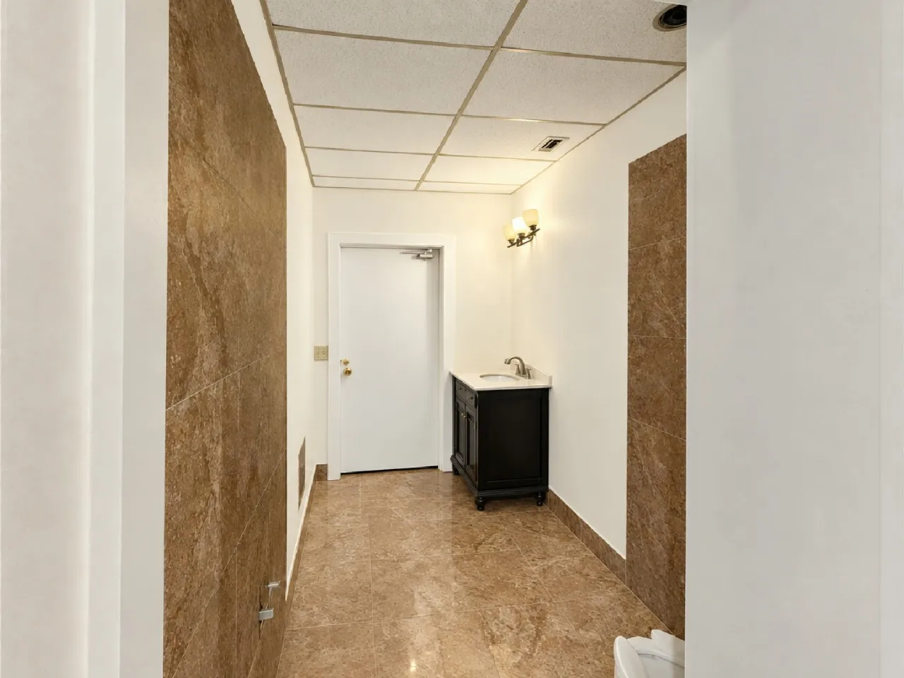 Hallway with full height stone-look wall panels and coordinating floor tiles