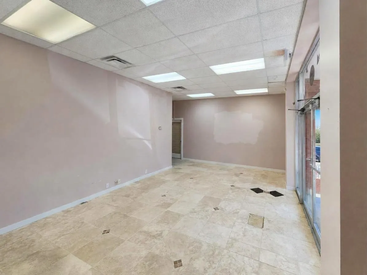 Recessed fluorescent lighting, drop ceiling, tile flooring with decorative accents, and full-light glass entry doors