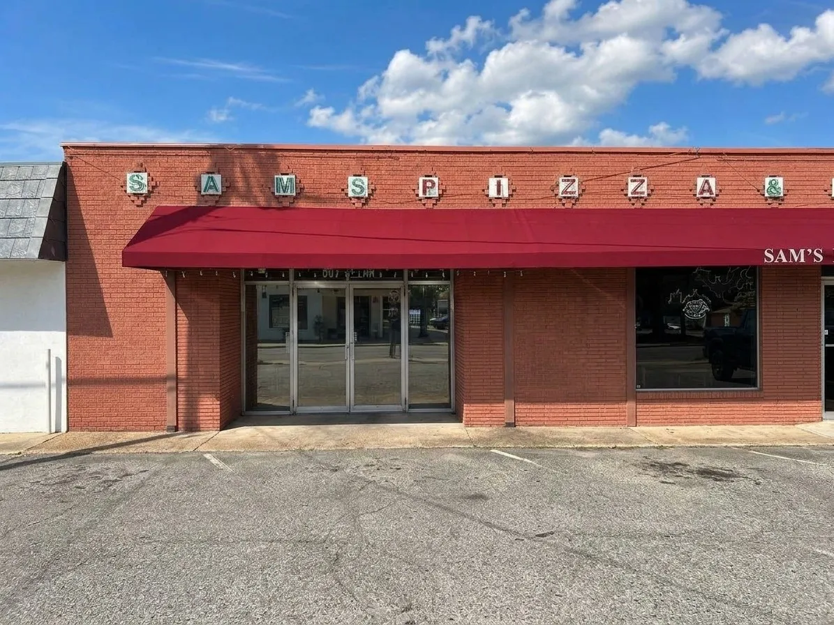 Red brick facade with a red awning