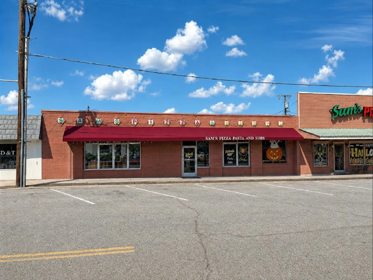 Brick exterior with a prominent red awning, large storefront windows, and dedicated front parking