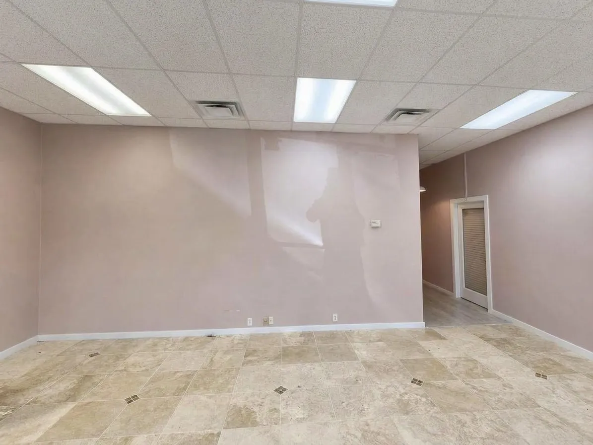 Recessed lighting, tile flooring with decorative accents, drop ceiling, and a white interior door with a textured glass panel