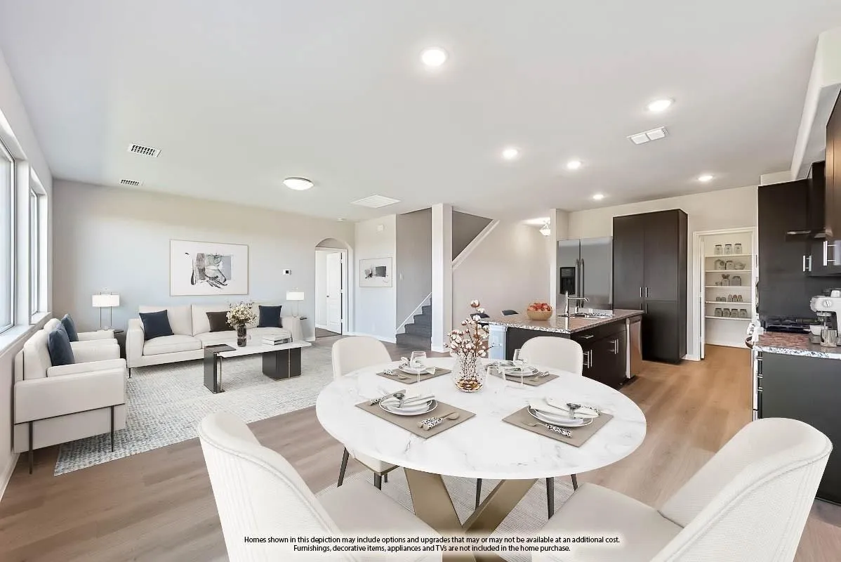 Open-concept living space featuring wood-finish flooring, recessed lighting, and large windows