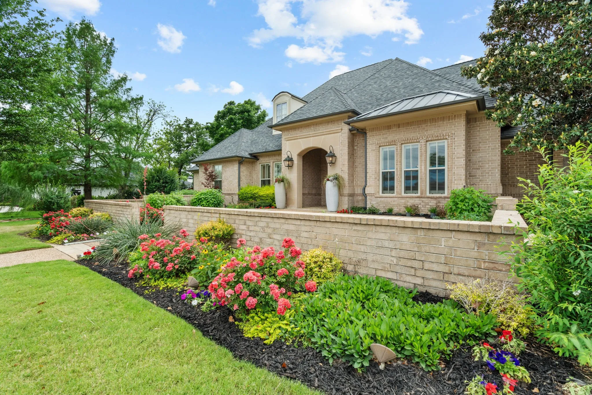 Brick exterior with arched entry, multi-pane windows, and a dark shingle roof
