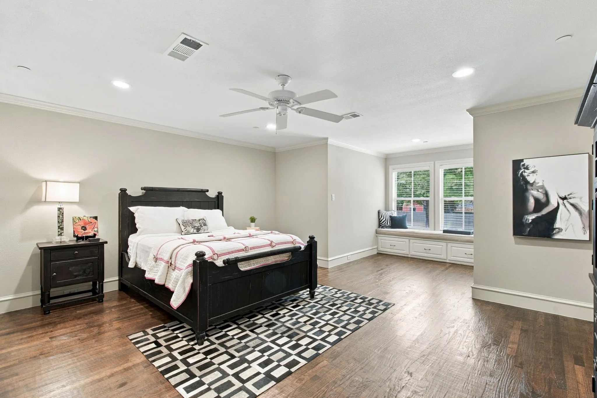 Hardwood flooring, recessed lighting, ceiling fan, white crown molding, and a built-in window bench with storage