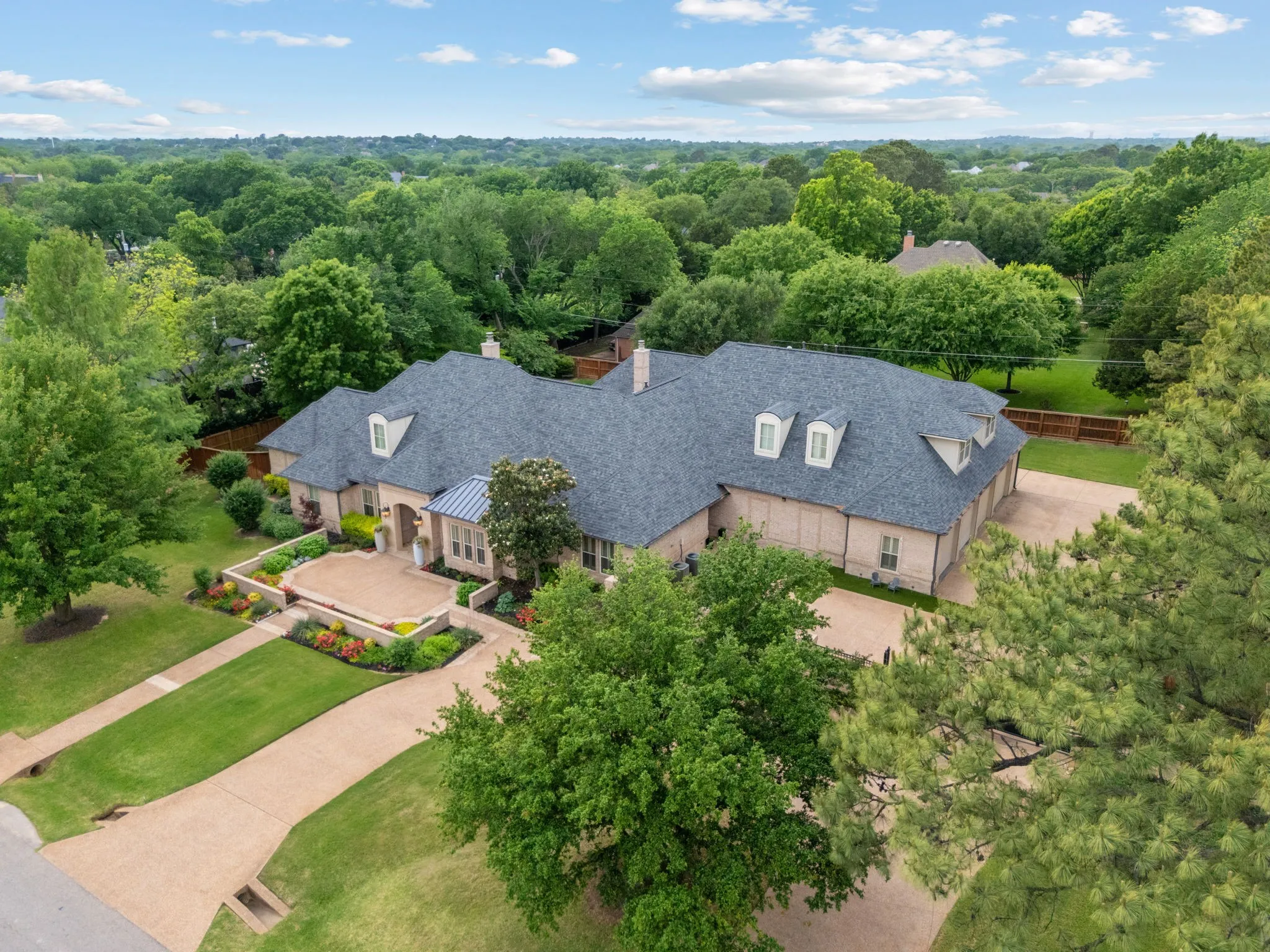 Expansive property featuring a multi-gable roofline, dormer windows, and a brick exterior