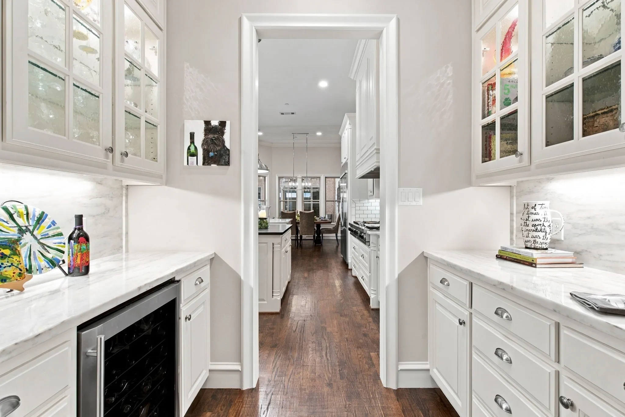 Built-in dry bar featuring white cabinetry, stone countertops, and wood-finish flooring