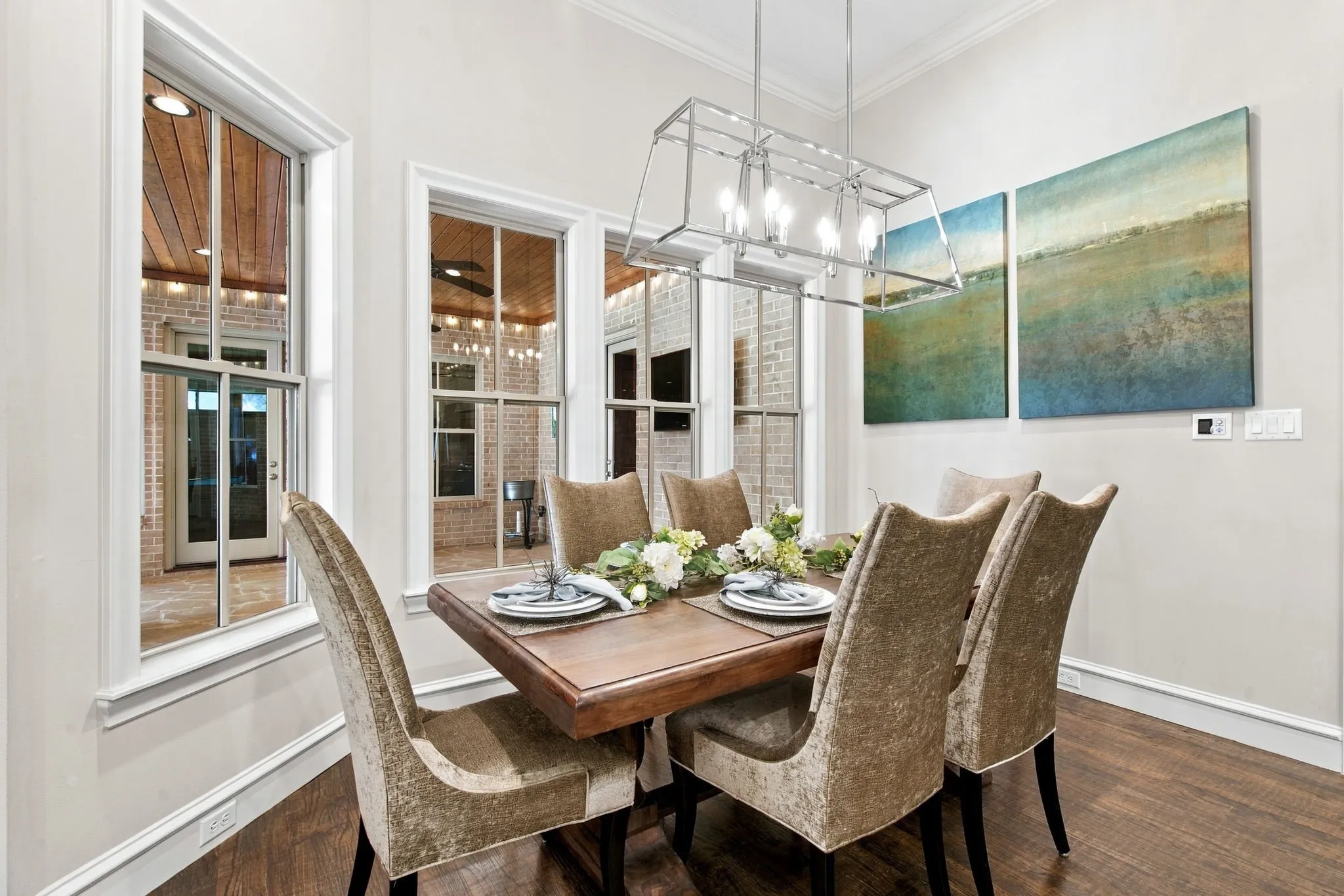 Dining area featuring wood-finish flooring, white trim, and a linear chandelier