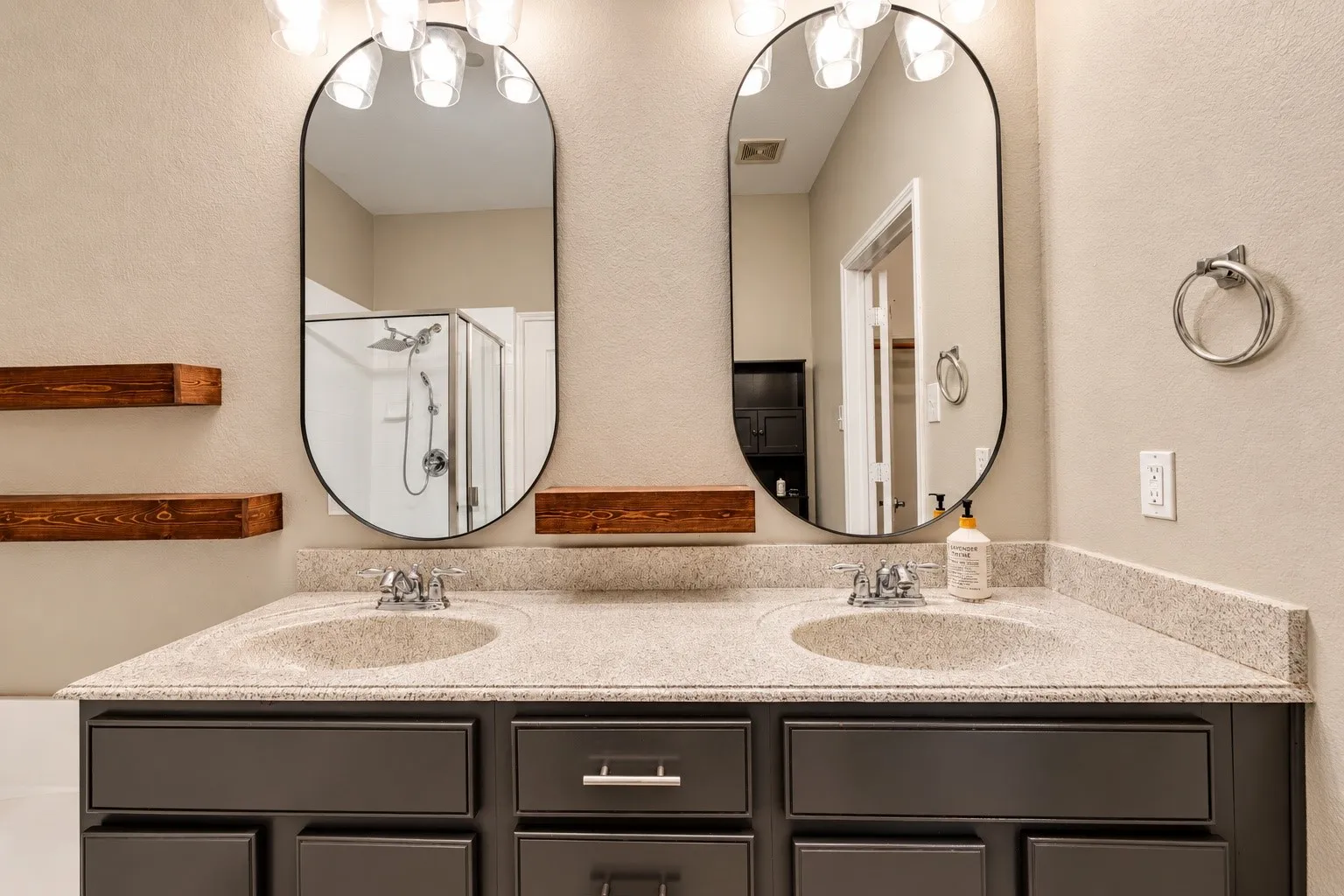 Dual vanity with a speckle-patterned countertop, under-mount sinks, and chrome-finish faucets