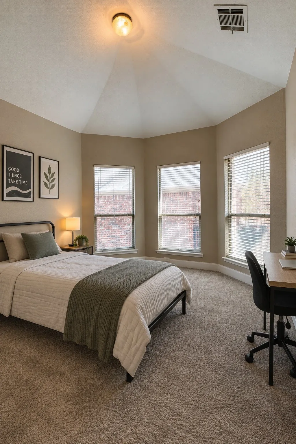 Vaulted ceiling, multiple windows with blinds, wall-to-wall carpeting, and a built-in ceiling light fixture