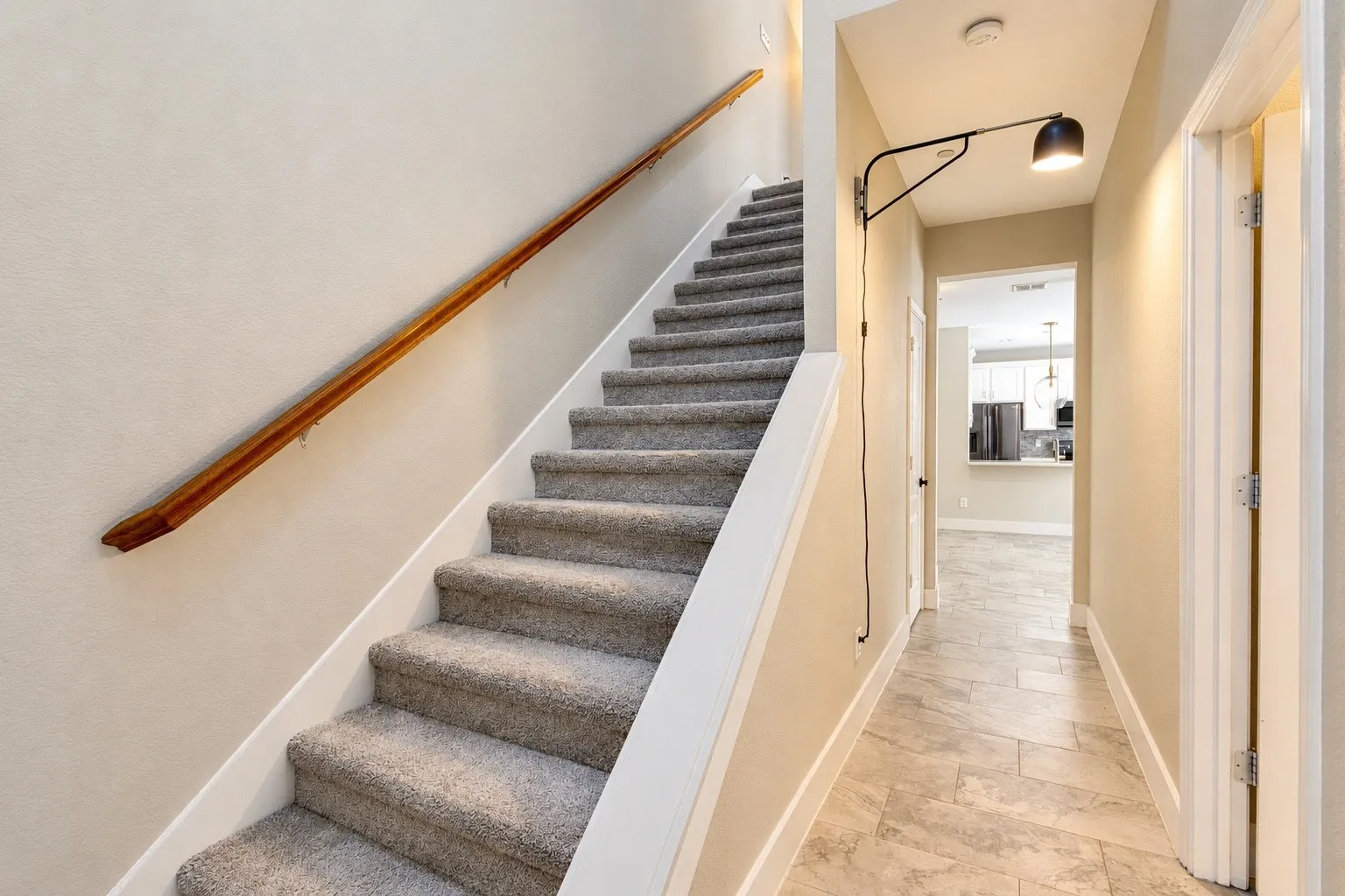 Carpeted staircase with a wood-finish handrail