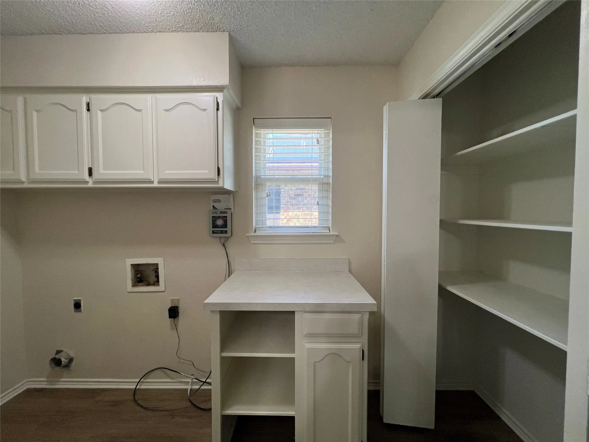 White cabinetry, built-in shelving, work surface, wood-finish flooring