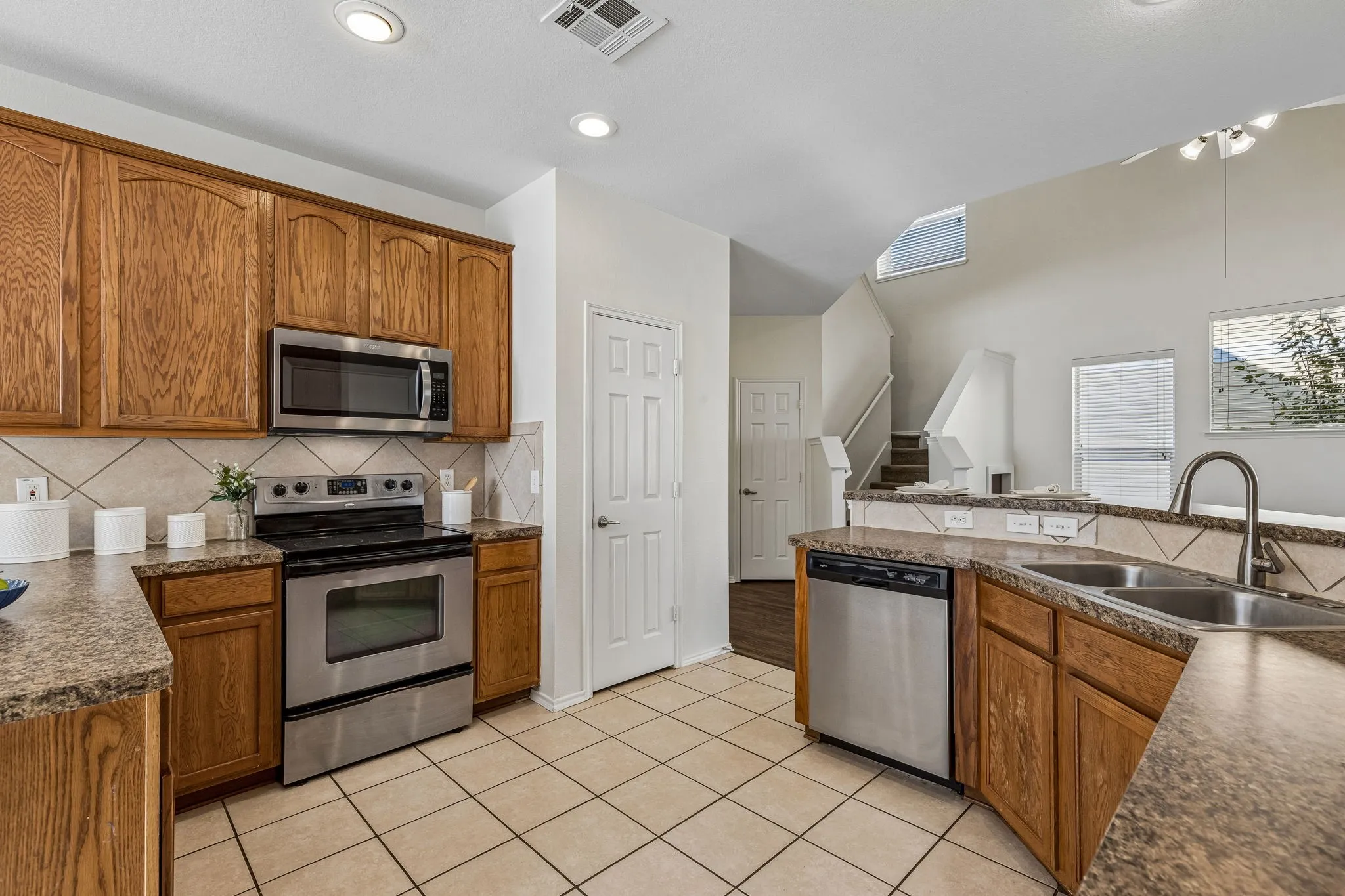 A tumbled marble accent wall adds warmth and architectural character to the breakfast bar.