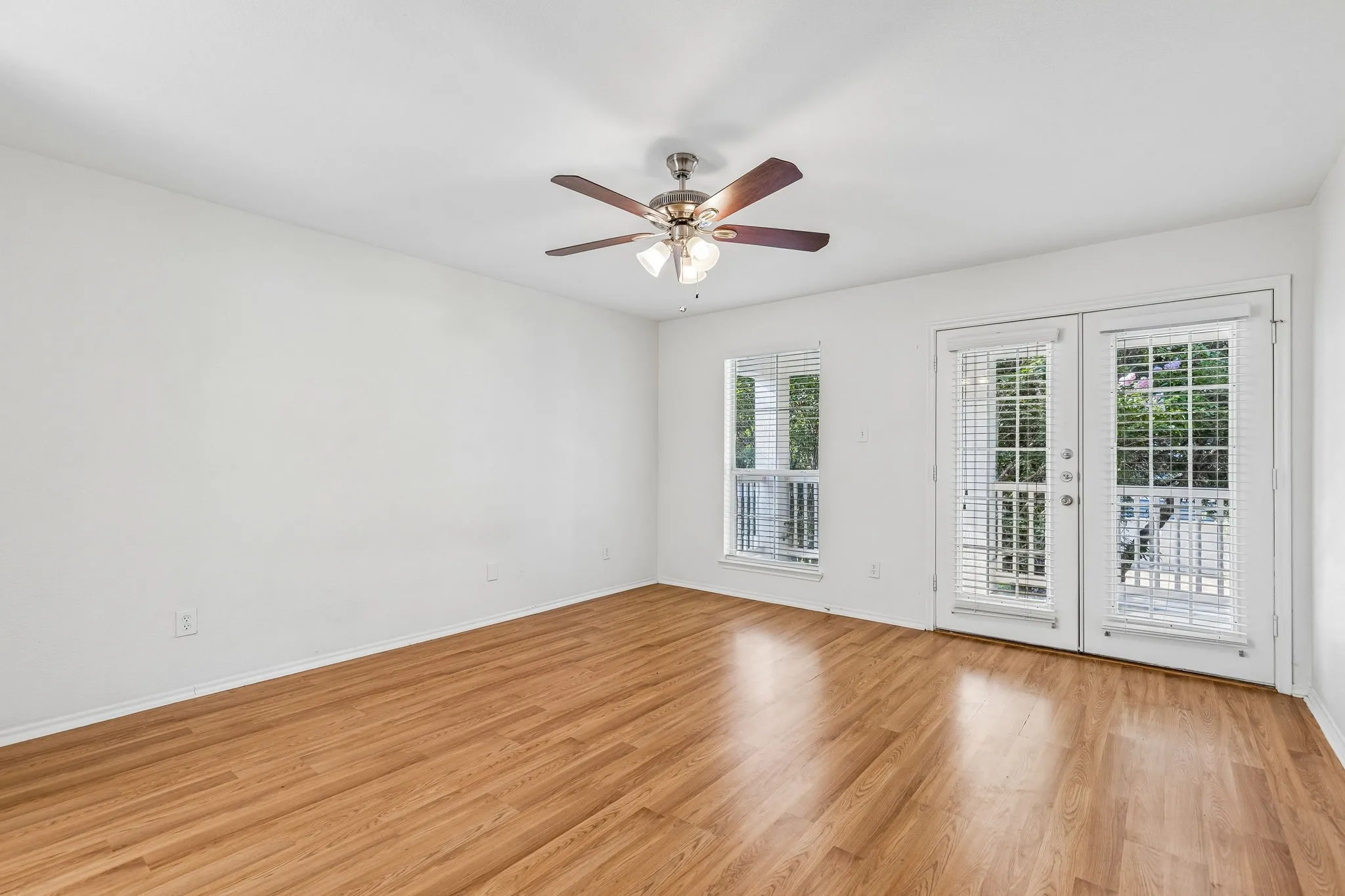 The spacious primary suite offers private access to the covered second-story balcony, creating a peaceful retreat.