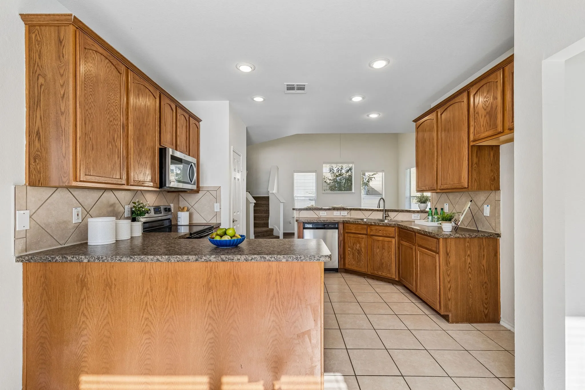 The open-concept kitchen offers abundant cabinetry, generous prep space and seamless connection to the family room for easy entertaining.