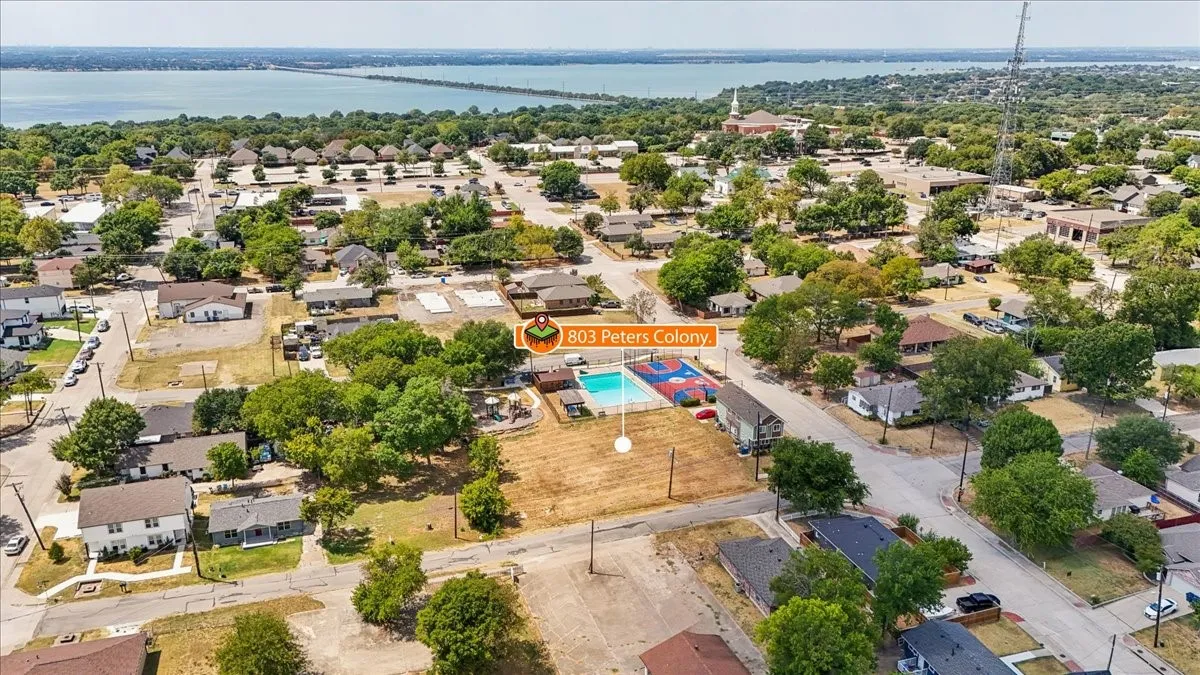 Aerial perspective of a residential neighborhood with a large body of water in the background