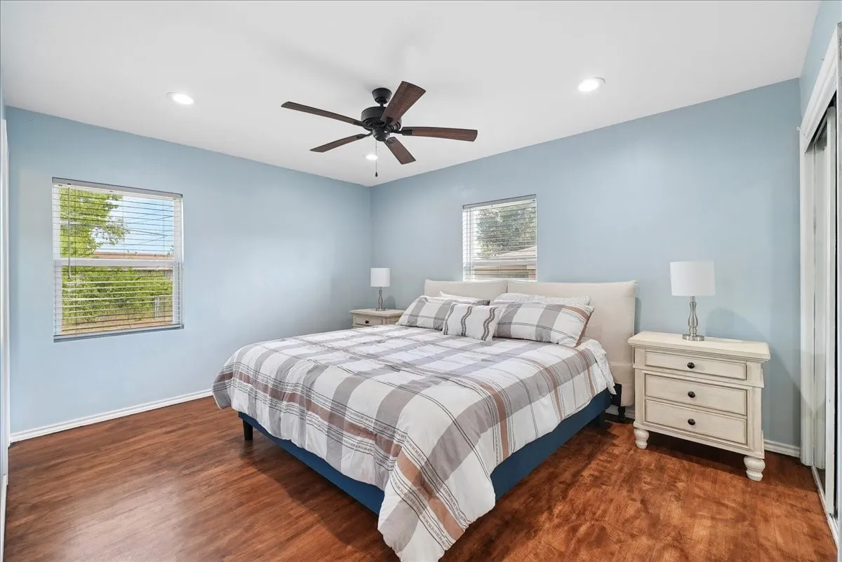 Recessed lighting, ceiling fan, wood-finish flooring, and two windows with blinds