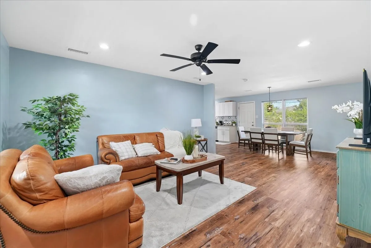 Open-concept living area featuring wood-finish flooring, recessed lighting, and a ceiling fan