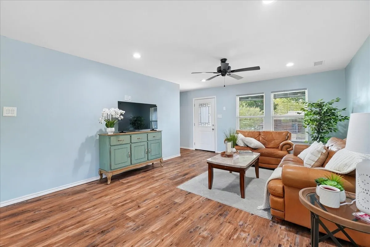 Expansive room featuring wood-finish flooring, recessed lighting, and a ceiling fan