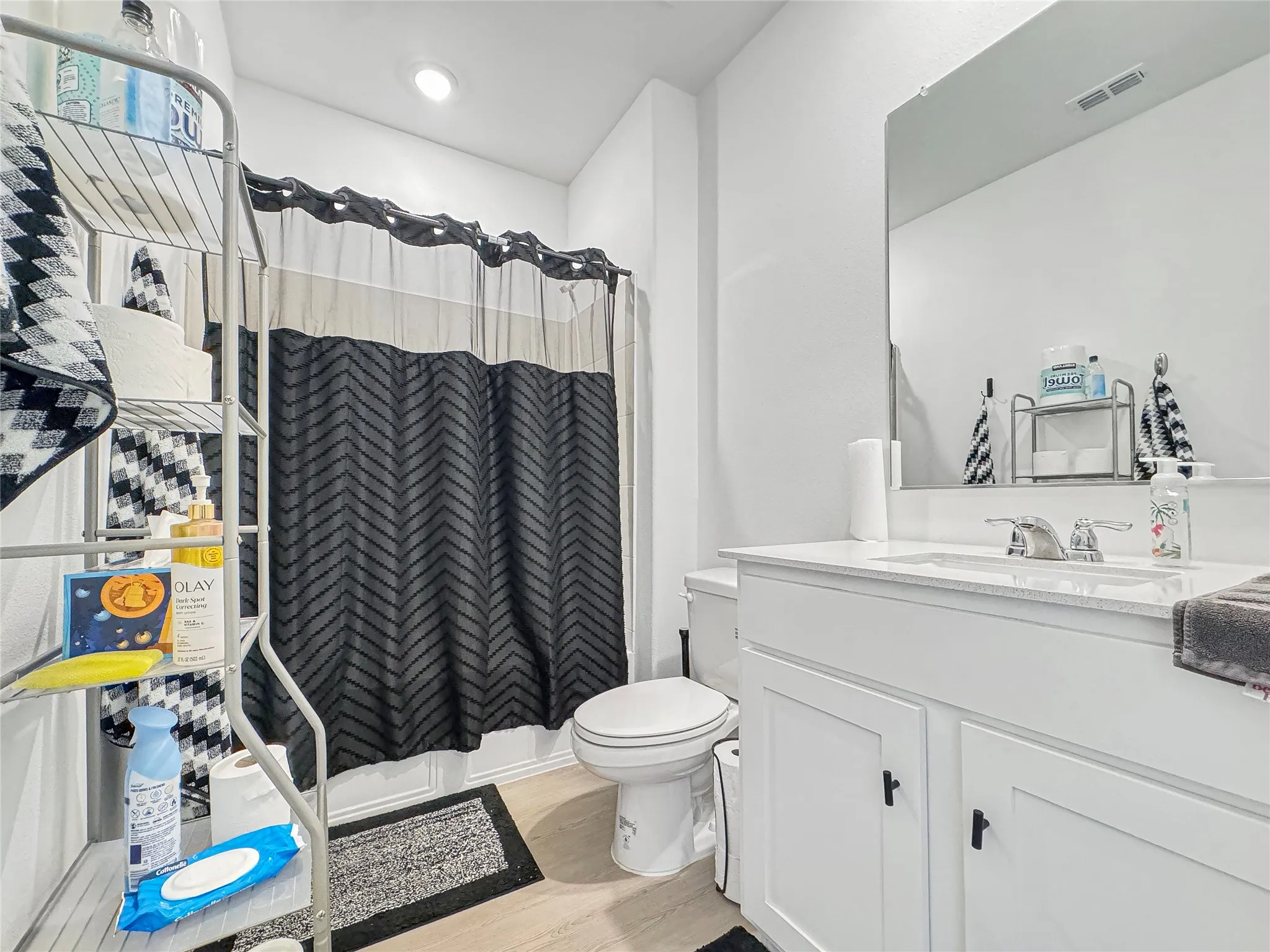 White vanity with integrated sink, chrome faucet, and rectangular mirror