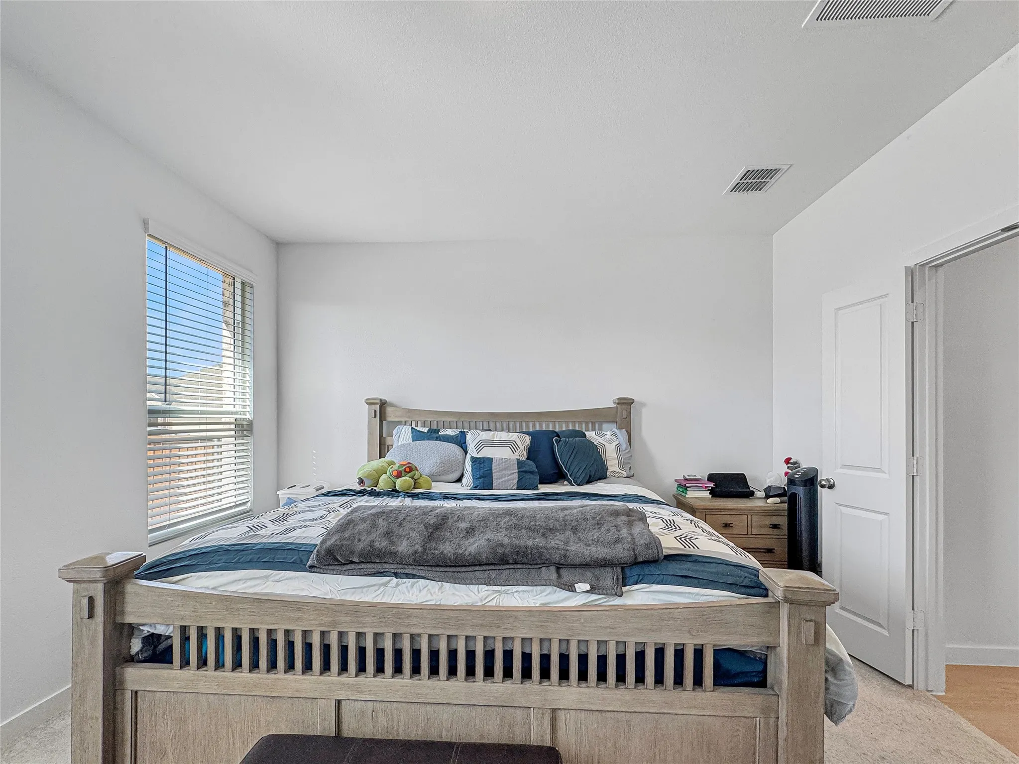 Recessed lighting, window with blinds, paneled interior door, light-toned carpeting