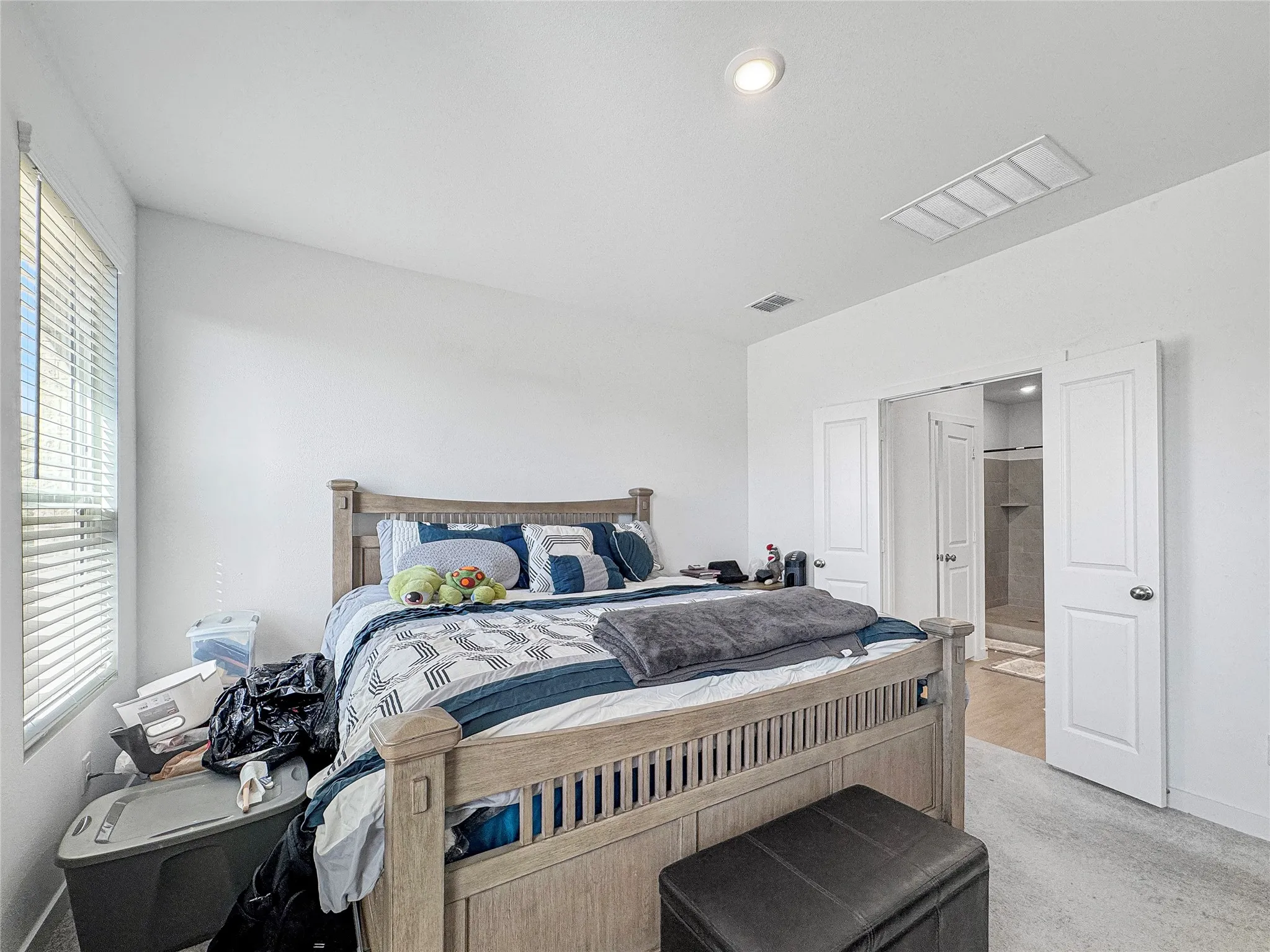 Recessed ceiling lighting, white interior doors, window with blinds, light-toned carpeting, and an adjoining room with tile flooring