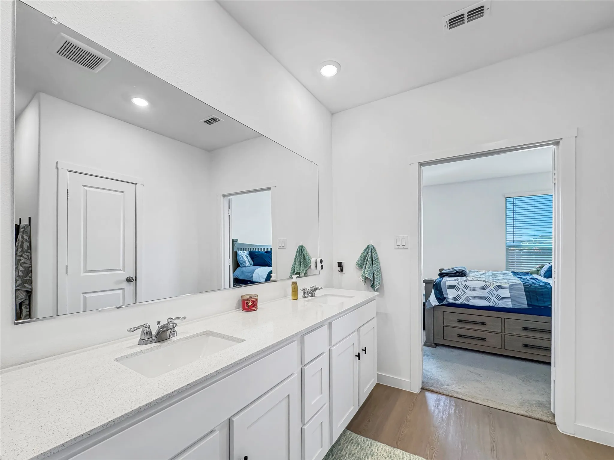 Double vanity with integrated sinks and chrome fixtures, ample counter space, custom cabinetry, and a full-width mirror