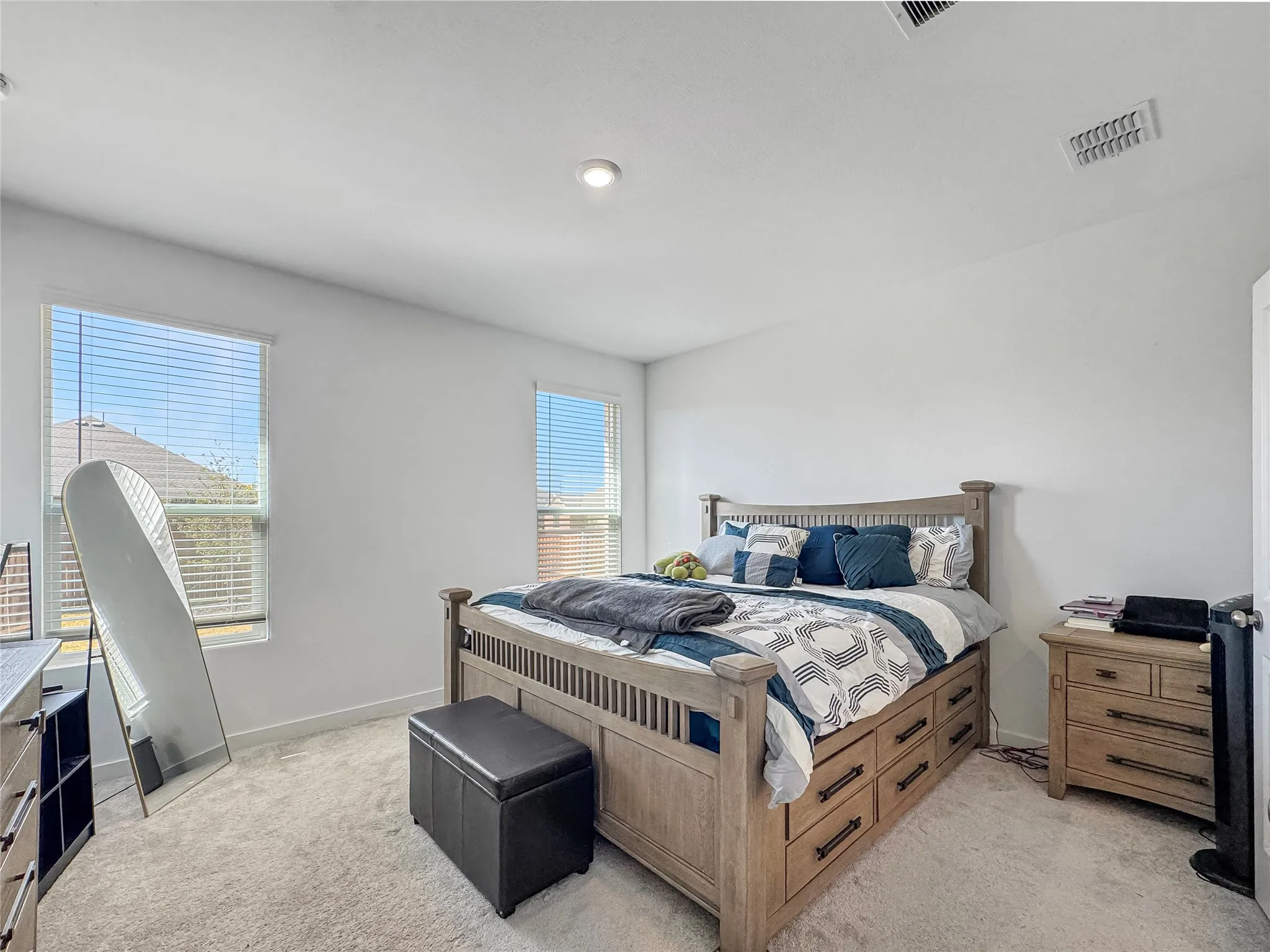 Plush carpet flooring, recessed lighting, and dual windows