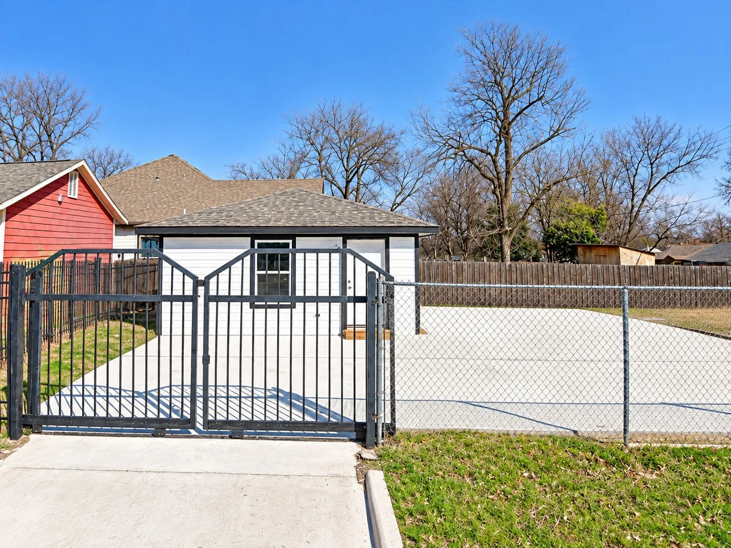 Private gated entry with concrete driveway and chain-link fencing