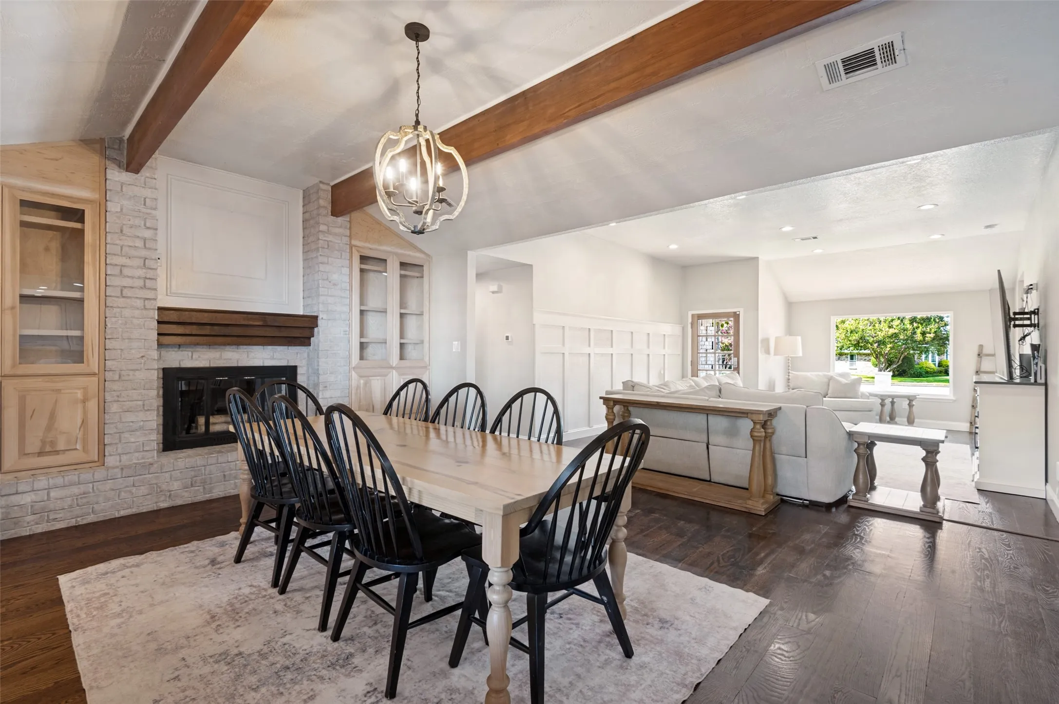 Exposed wood beams in dining, vaulted ceiling, built in custom cabinets and recessed lighting enhance the open-concept living space