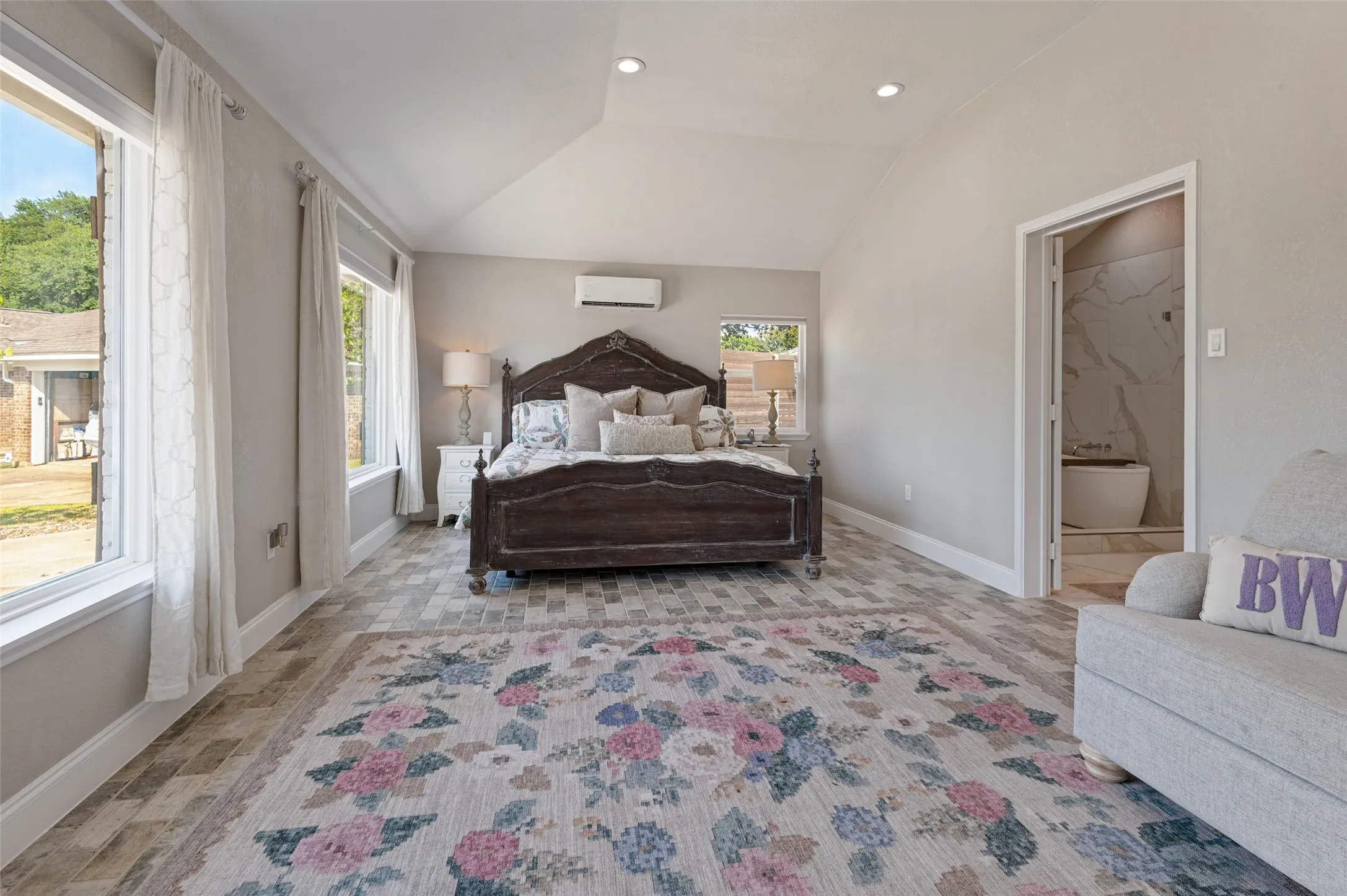 Primary bedroom featuring vaulted ceiling with recessed lighting and beautiful flooring