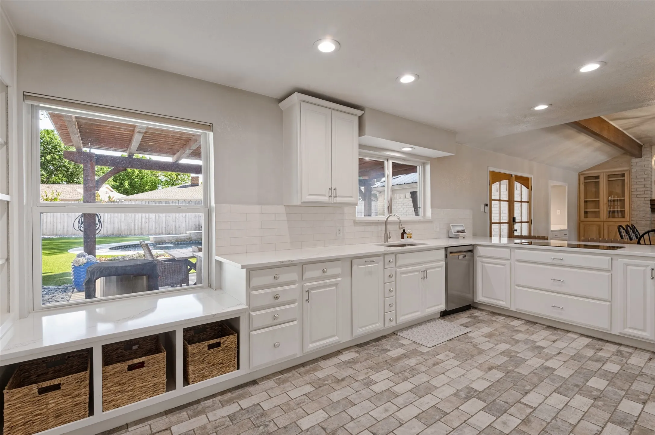 Kitchen with white custom cabinetry, quartz countertops, subway tile backsplash, and stainless steel appliances
