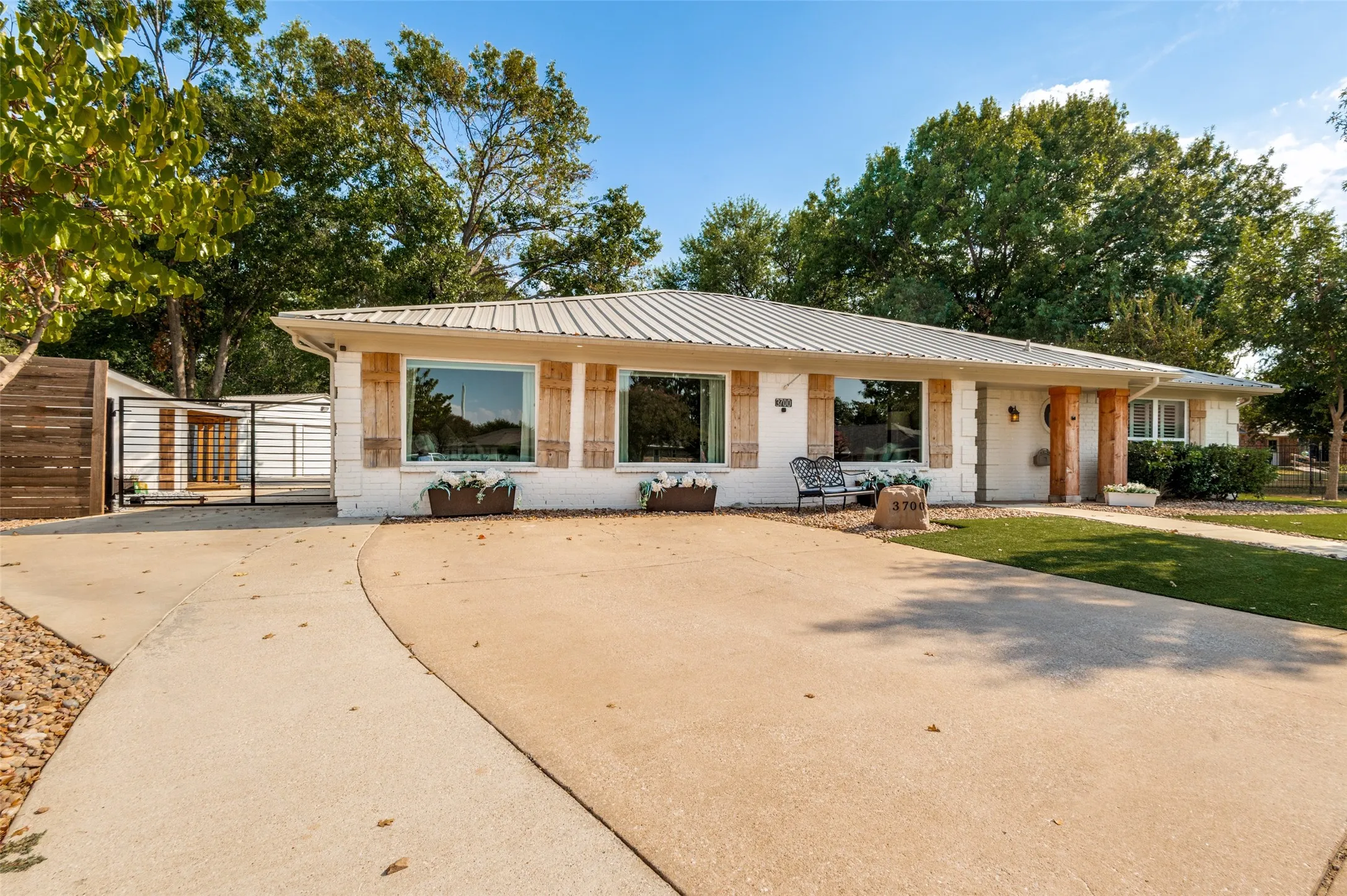 White exterior with a metal roof, wood-finish window shutters