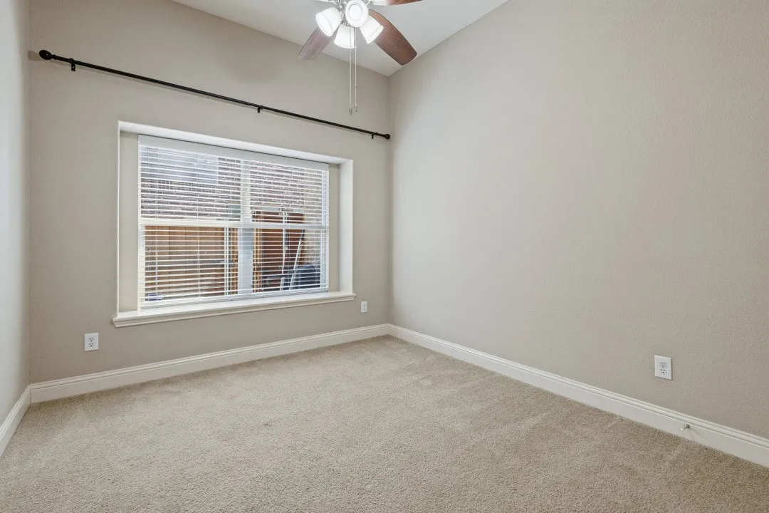 Vaulted ceiling with a ceiling fan, neutral carpet flooring, and a window with blinds