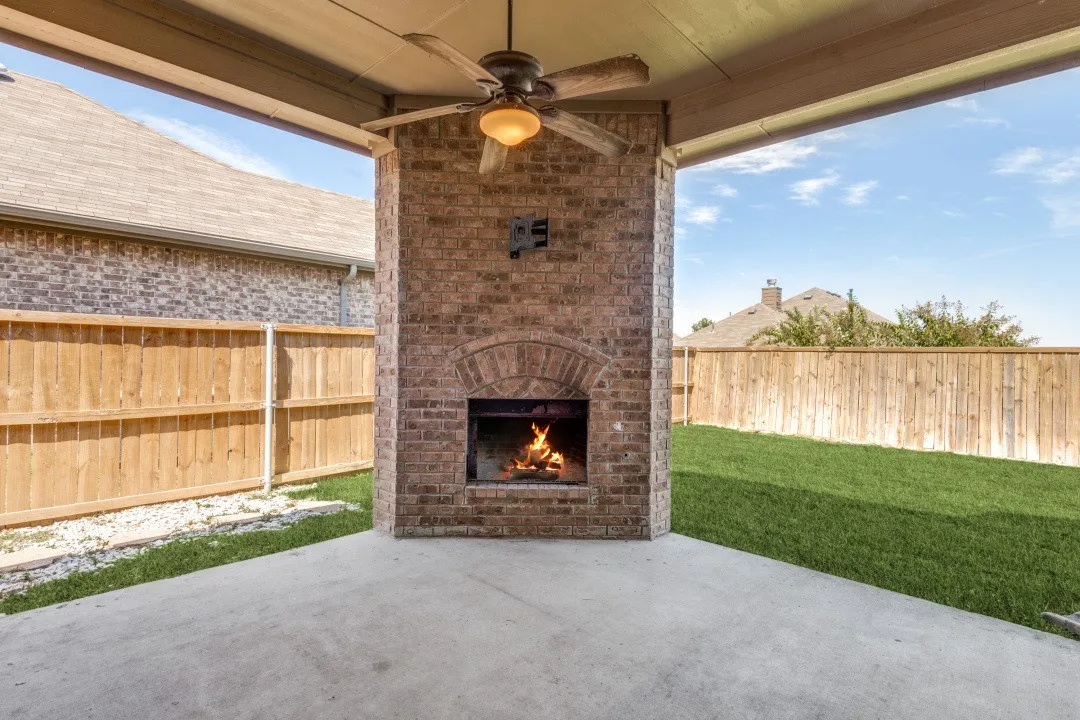 Oversize covered rear patio with working fireplace and ceiling fan. Perfect for relaxing evenings and always in the shade