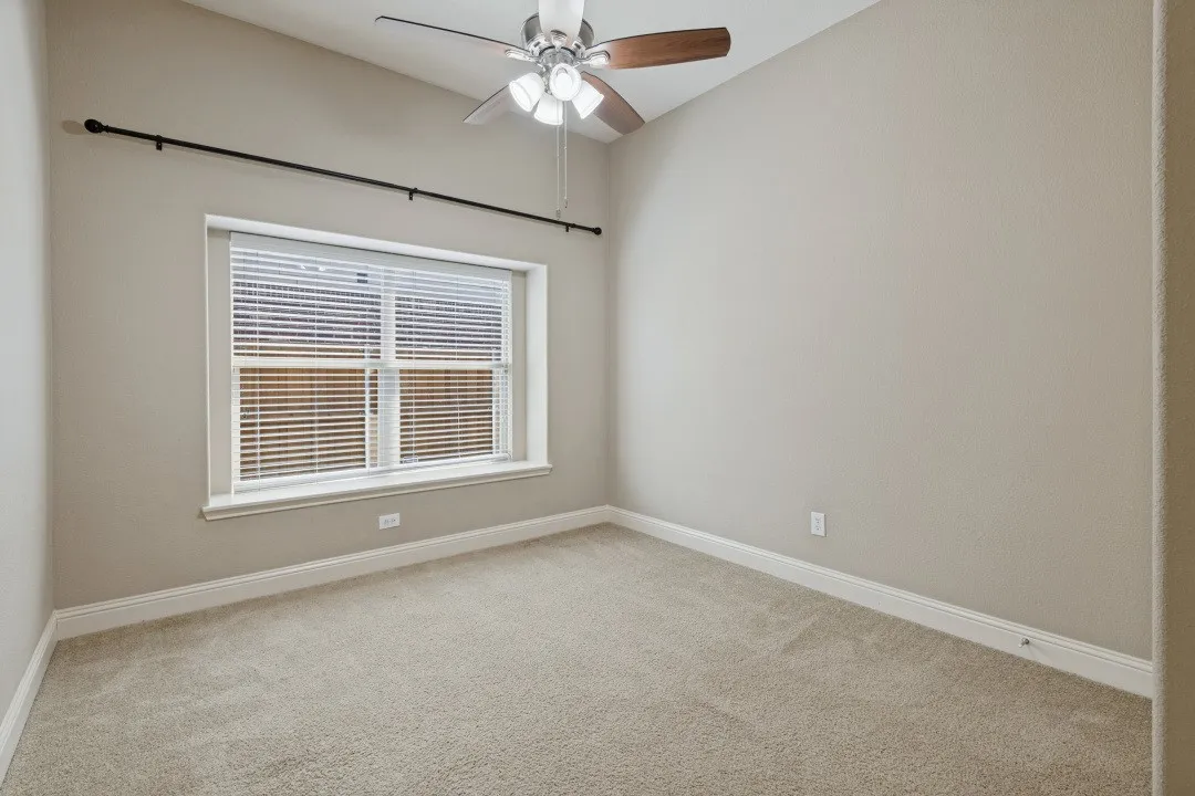 Vaulted ceiling with a ceiling fan, window with blinds, and neutral carpeting