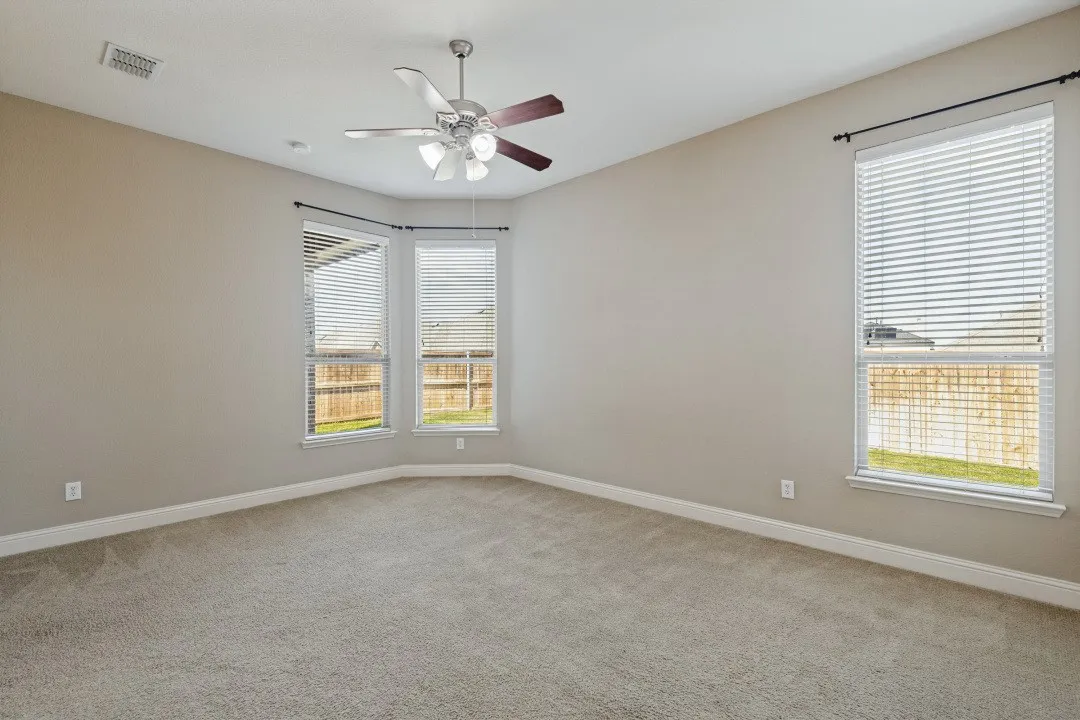 Huge oversized primary bedroom with windows facing the covered patio and the fireplace. Plenty of room for a sitting area and your biggest furniture