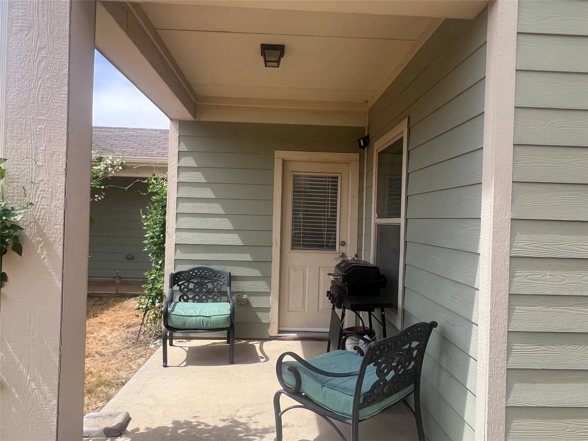 Covered patio featuring concrete flooring and a privacy wall
