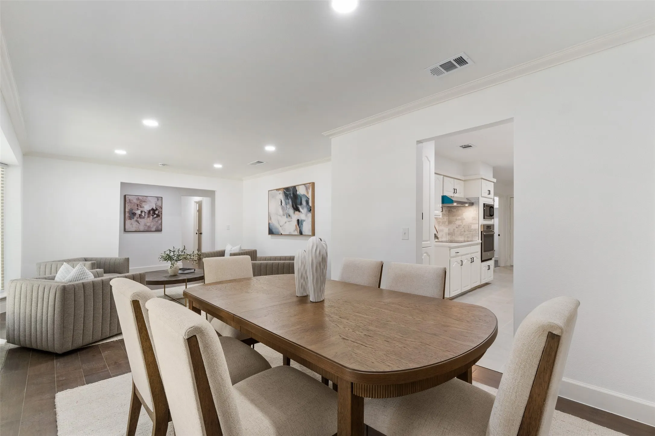 Recessed lighting, crown molding, wood-finish flooring, white cabinetry, and built-in kitchen appliances