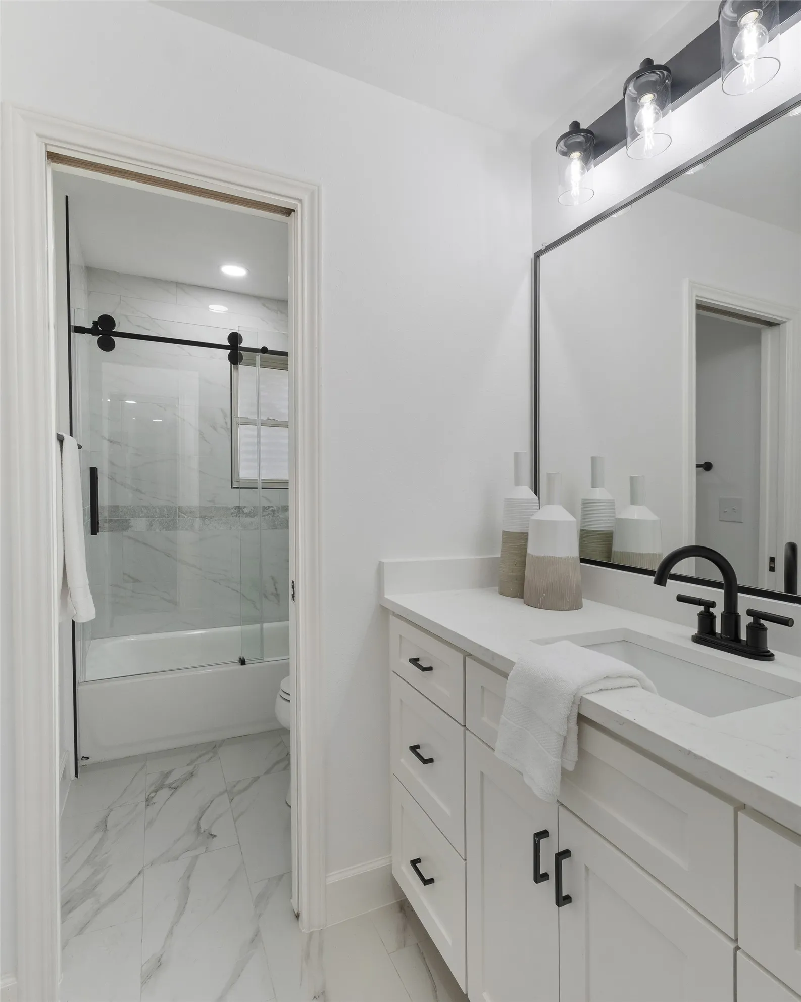 White shaker vanity with a quartz countertop, undermount sink, and matte black faucet