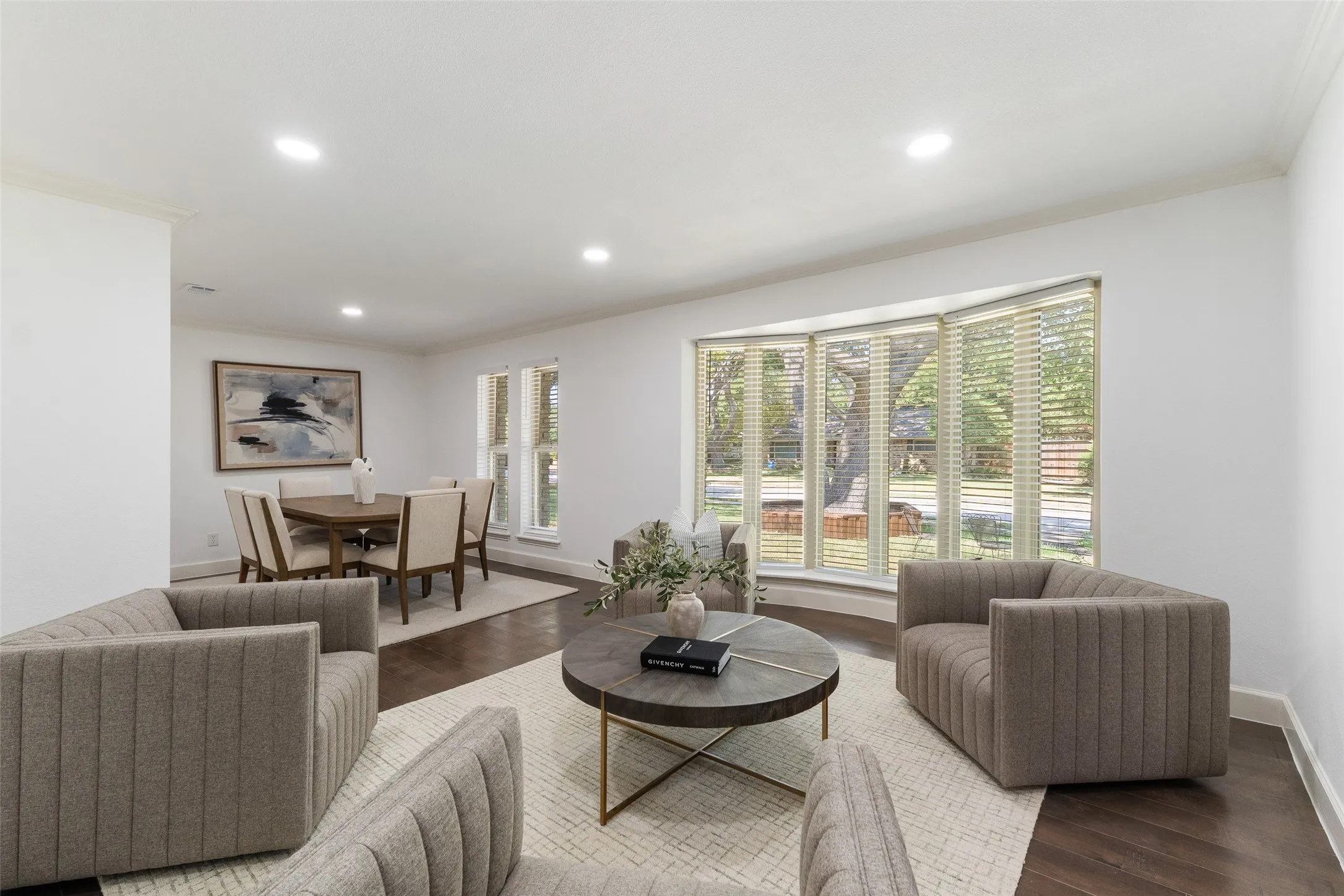 Bay window with natural light, recessed lighting, crown molding, and wood-finish flooring
