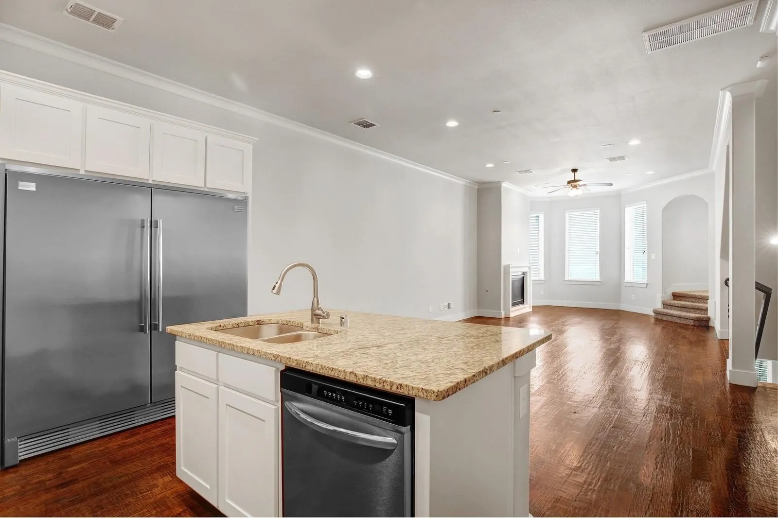 Kitchen island with granite countertop, double basin sink, and integrated dishwasher
