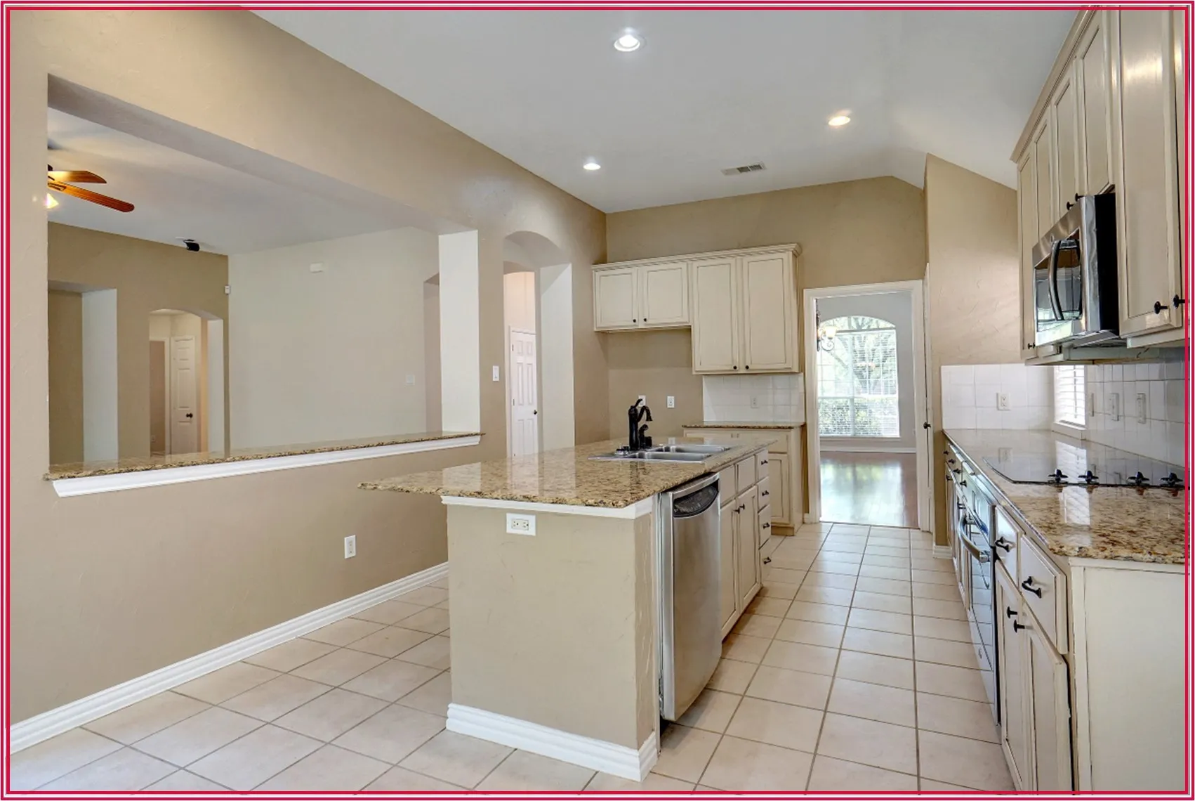 Kitchen featuring tile flooring, stone-finish countertops, stainless steel appliances, and white cabinetry
