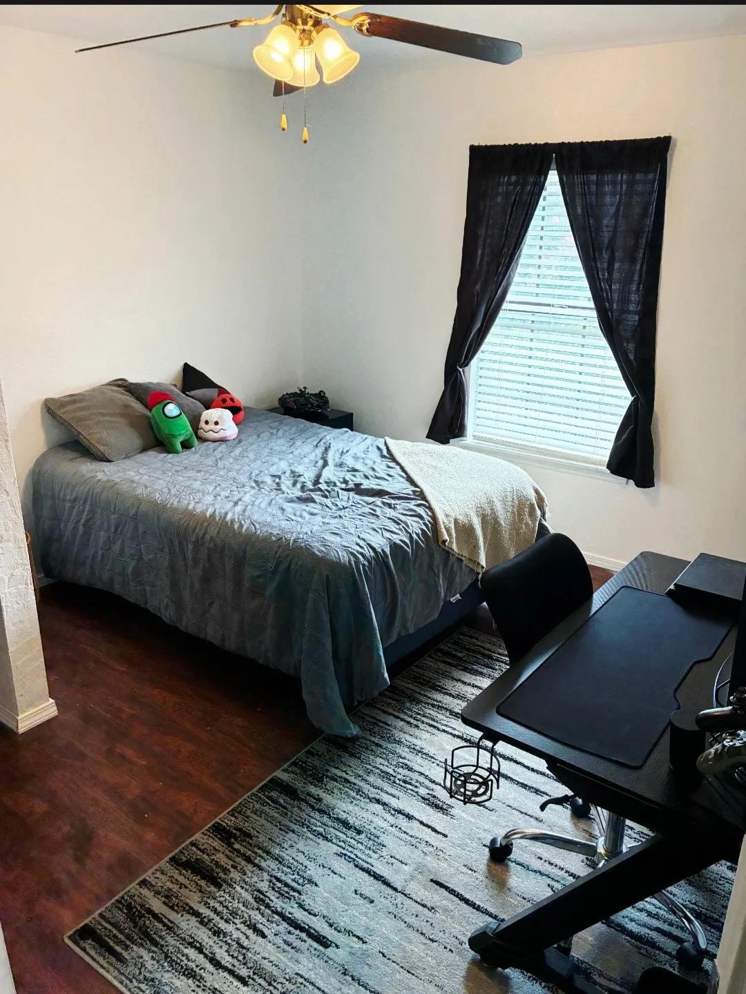 Wood-finish flooring with a ceiling fan light fixture and a window with blinds