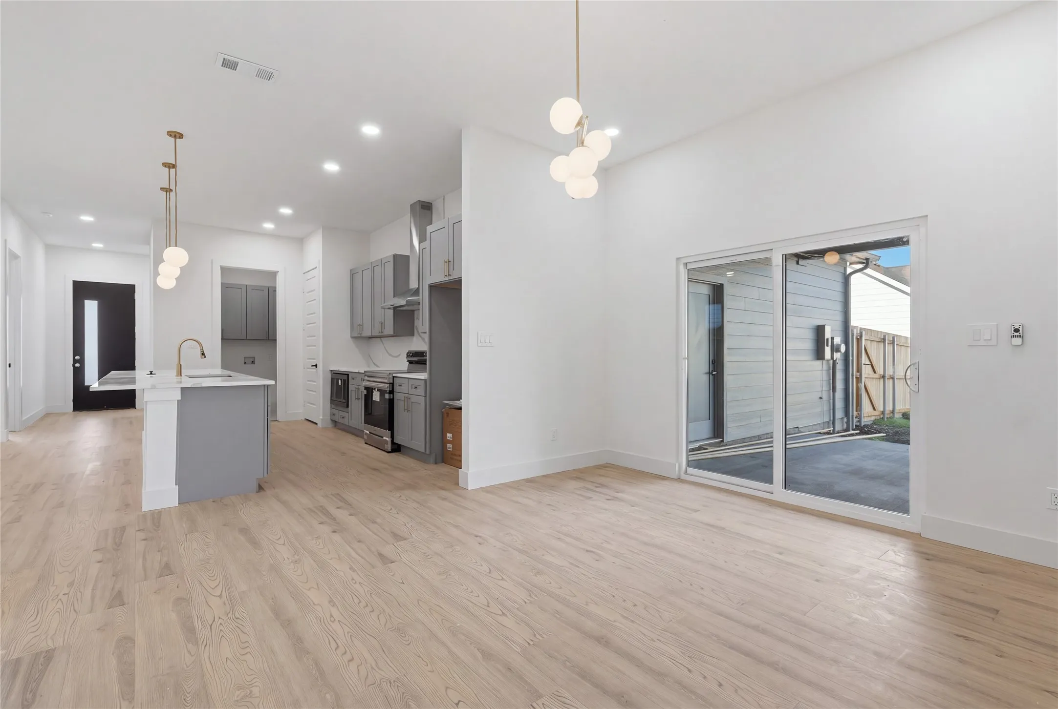Open-concept living space featuring wood-finish flooring, recessed lighting, and a modern kitchen with stainless steel appliances