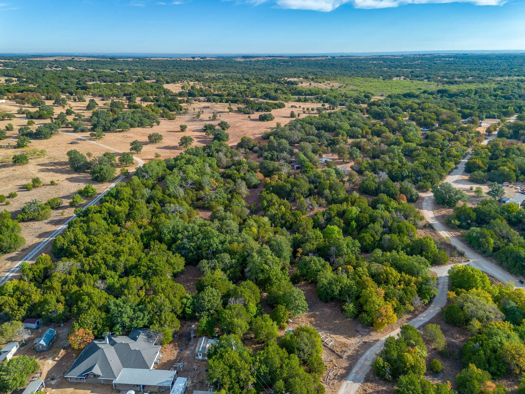 Expansive rural landscape featuring a mix of mature trees and open fields