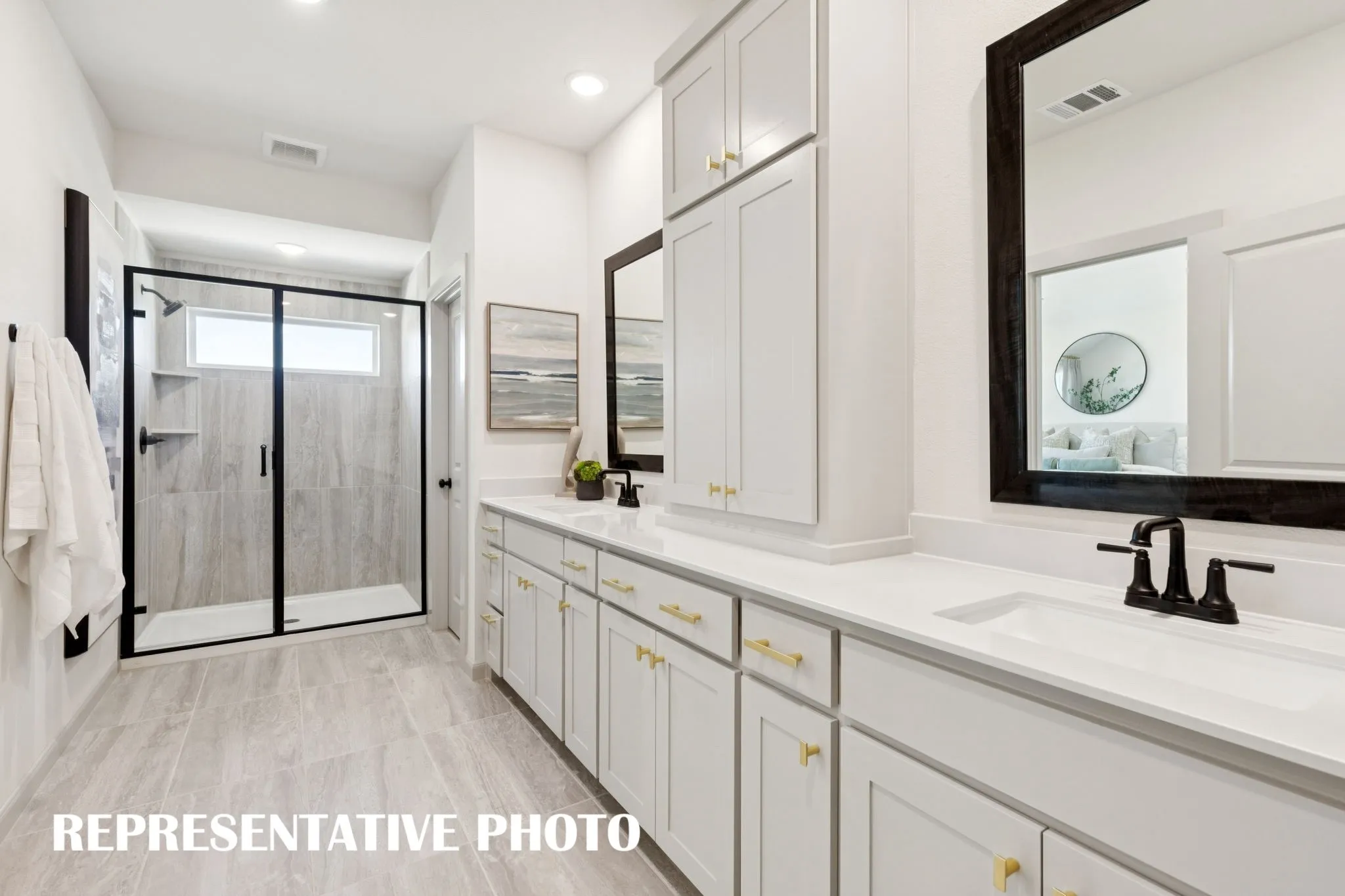 Offering a spacious walk in shower plus plenty of storage and counter space, this owner's bath is a dream come true!  REPRESENTATIVE PHOTO