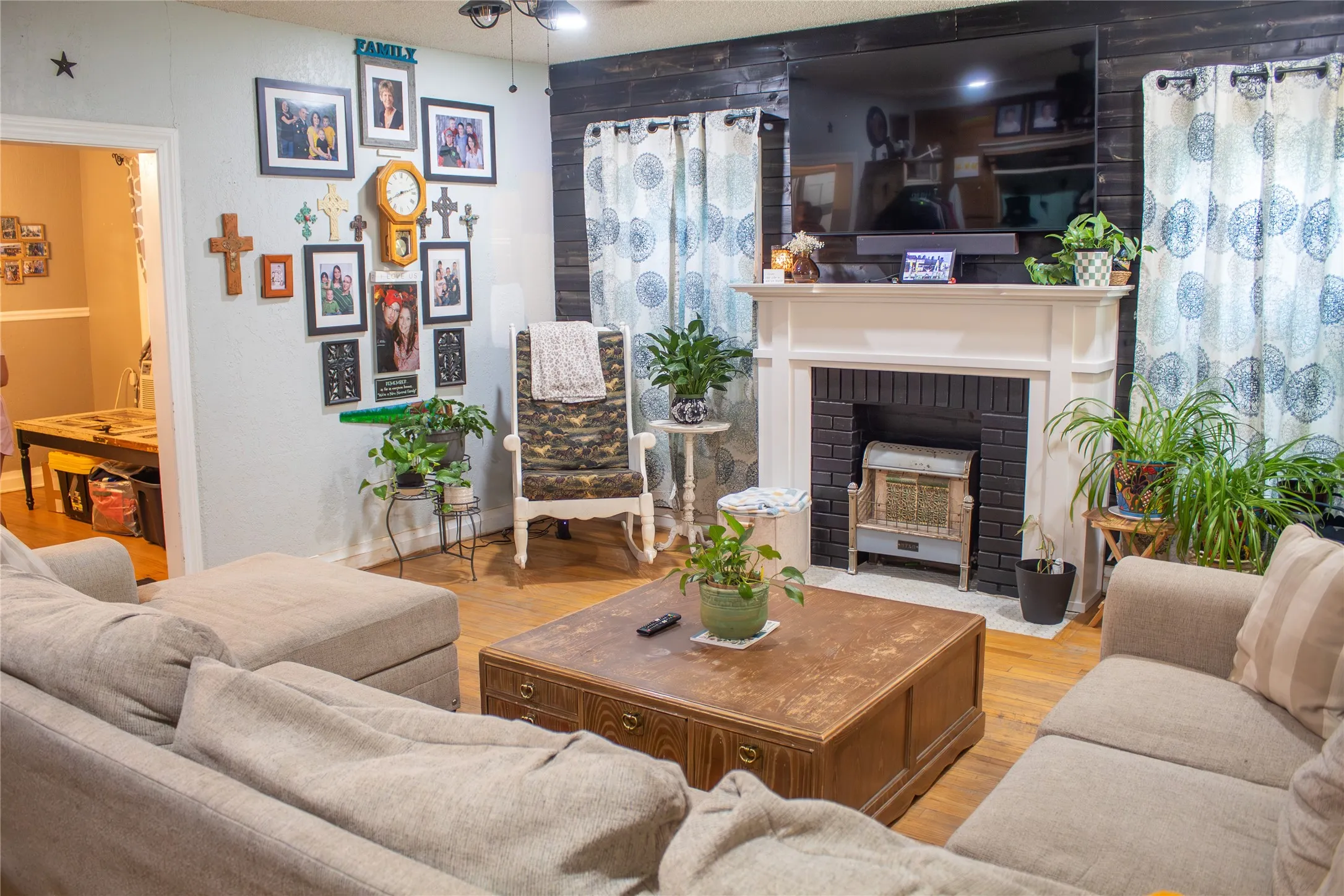 Hardwood-style flooring in the living area with a built-in fireplace featuring a white mantel and black brick surround
