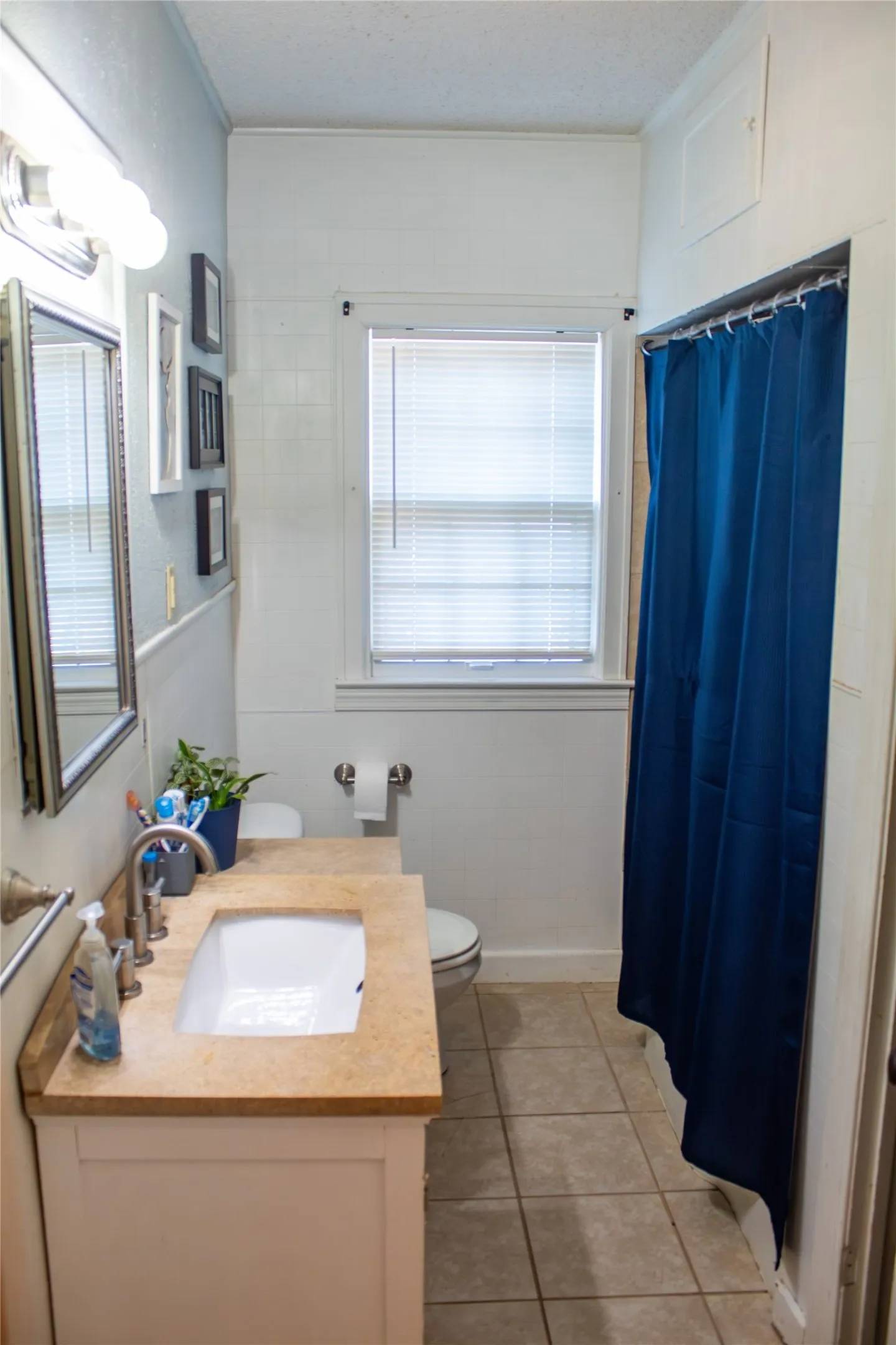 White vanity with a neutral-toned countertop and an undermount sink